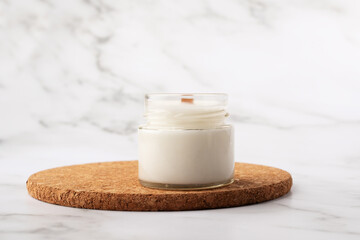 Candle on a cork stand in the bathroom on marble background