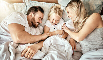 Bed, top view and happy family bond with tickle, games and laughing in their home together. Bedroom, fun and above parents with girl child in a house with care, support and love, security or playing