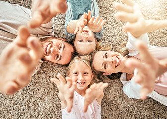 Happy family, children and parents on floor, smile and happiness with hands, enjoying and playing. Morning, mom and dad with girls, home and bonding together in top view, playful and affectionate