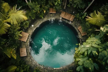 Papier Peint photo Bali Top view of the circular pool with wooden sunbeds in the rainforest.