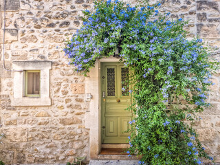 Door decorated by flowers in Provence, Maussane-les-Alpilles, South of France - 658310738