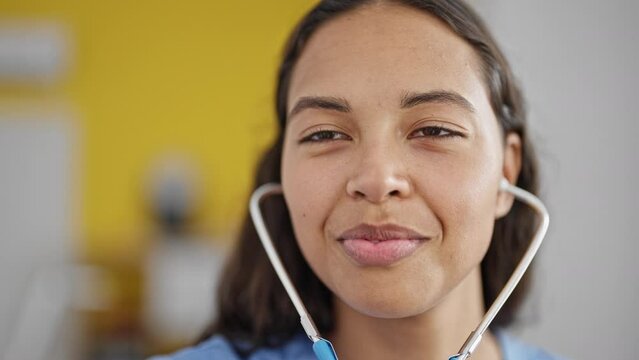 African american woman doctor smiling confident using stethoscope at clinic