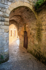 Fototapeta na wymiar The ancient stone arched entrance to a castle that once stood below the Trogladytic Fort at La Roque-Gageac in the Dordogne region of France 