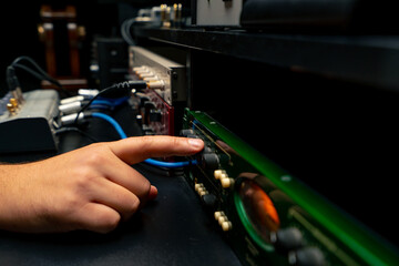 close-up shot of the male hand of a sound engineer switching settings on mixing console for...