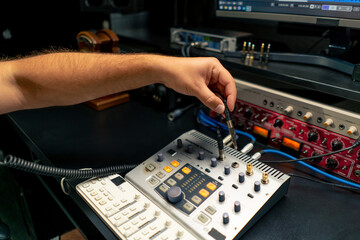 close-up shot of the male hand of a sound engineer switching settings on mixing console for...