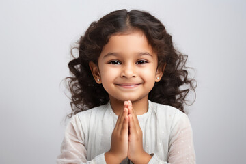 Cute indian little girl child making namaste or praying gesture