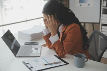 Asian women are stressed while working on laptop, Tired asian businesswoman with headache at office, feeling sick at work, copy space - obrazy, fototapety, plakaty