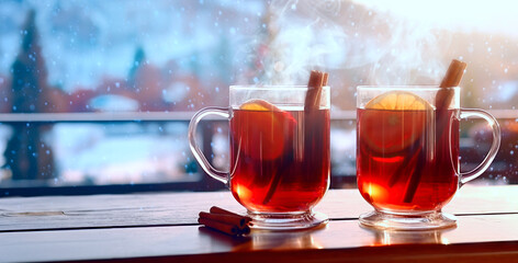 Fresh hot mulled wine on a wooden table at a ski resort. Winter Christmas holidays in an alpine hotel or restaurant or cafe. Snowy winter day.