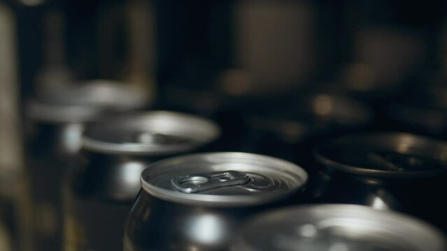 Smooth camera movement of metal soda cans on a store window. Grocery store shelf metal cans with beer on display of beer bar. Close up of aluminum beer cans in a store