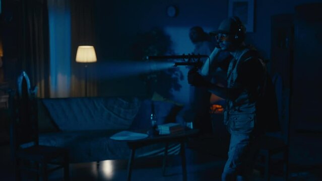 Zoom in video capturing two ghost hunters entering a dark room in search for an entity that's making the lights flash, scanning the space with an EMF detector.