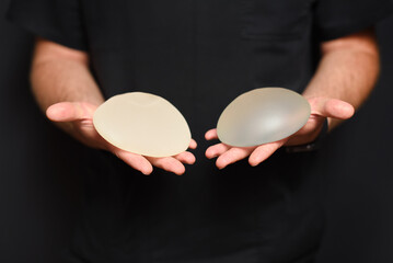 A doctor showing breast augmentation implants in her hands