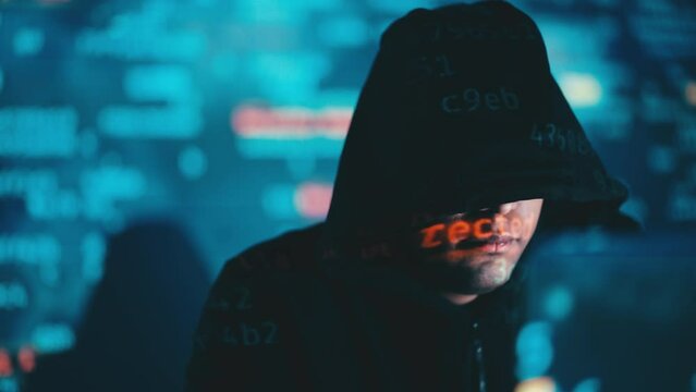 Hooded hacker breaching system, copying sensitive data, stereotypical hacking