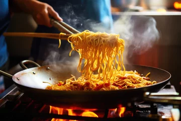 Foto op Canvas Chef cooking Stir-fried noodles with vegetables and spices in the wok. Asian cuisine © pilipphoto