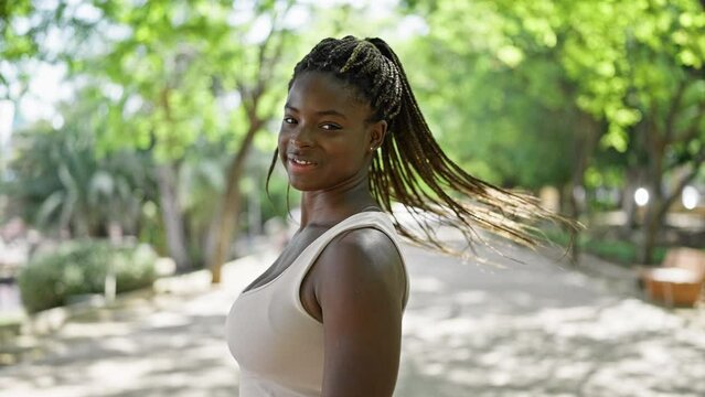 African american woman smiling confident turning by herself walking at park