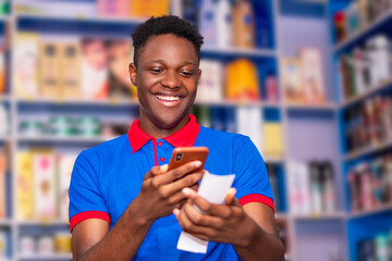 Excited Young african guy checking his betting slip and using his mobile phone
