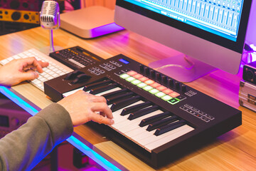 male musician, producer, arranger hands playing midi keyboard for recording music on desktop computer. music production concept - 658360188