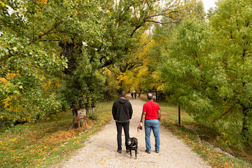 Hombres paseando con su perro por el bosque Finlandés en Rascafría, Madrid.