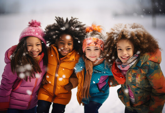 Happy excited children, friends enjoying the winter beauty, white snow falling in which children play and rejoice.