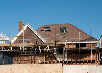 Europe, UK, England, Surrey, scaffolding on house roof renovation - obrazy, fototapety, plakaty