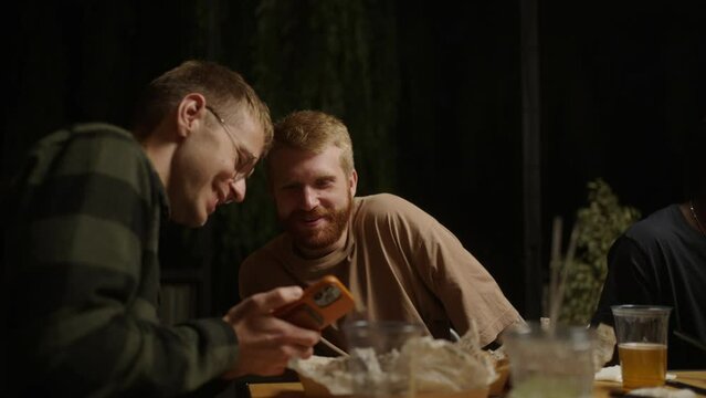 Young Men Friends Chatting At Party In Saturday Evening In Restaurant Or Bar, Buddies In Weekend