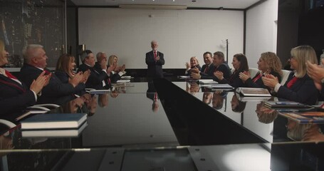 large group of senior professors attending the meeting and applauding together