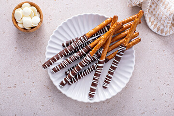 Chocolate dipped pretzel rods on a plate - obrazy, fototapety, plakaty