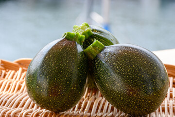 Round green courgette or zucchini, on wicked plate, close up, healthy food