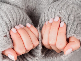 Women's manicure shellac soft pink color close-up