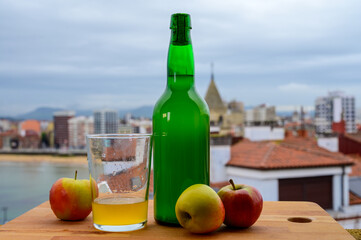 Traditional natural Asturian cider made from fermented apples in wooden barrels should be poured from great height for air bubbles into the drink and view on Gijon, Asturias, Spain