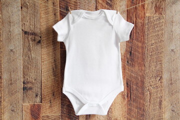 Baby onesie mock up . Blank bodysuit wooden wall	
