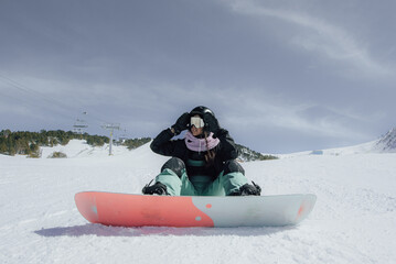 Woman in the mountains practicing snowboard.
