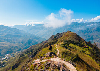 Un hombre joven caminando por las montañas.silueta de turista con mochila ,Viaje estilo de vida saludable excursión en solitario vacaciones activas al aire libre, Amplio panorama de montaña, 