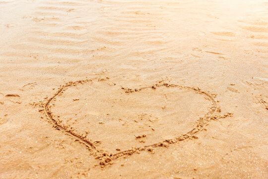 a painted heart on the sand on the beach