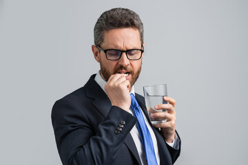 Man with headache on isolated gray studio background. Man feel pain rubbing dry eyes fatigued from work. Stressed man suffer from headache bad vision sight problem. Deadline and stressed job.