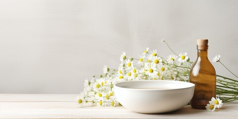 Obraz na płótnie Canvas Bowl with chamomile flowers and bottle of essential oil on light background : Generative AI