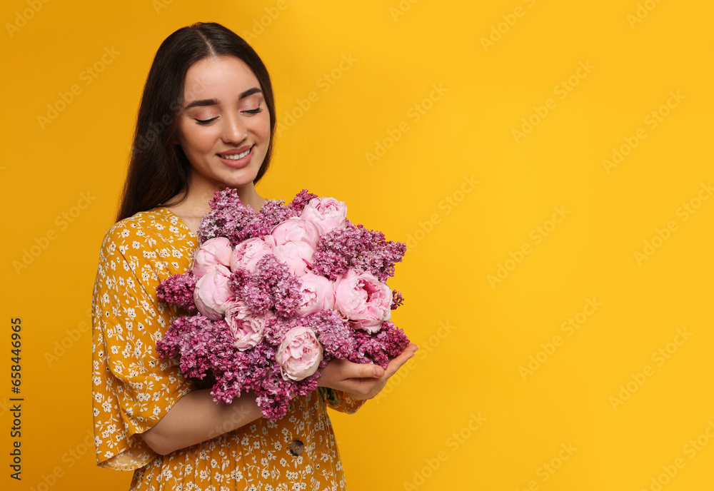 Canvas Prints Beautiful woman with bouquet of spring flowers on yellow background, space for text