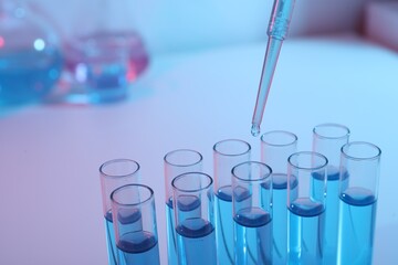 Dripping reagent into test tube with blue liquid, closeup. Laboratory analysis