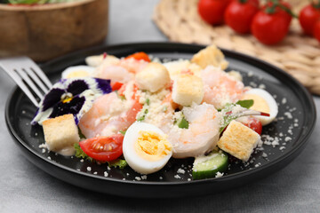 Delicious Caesar salad with shrimps served on grey table, closeup
