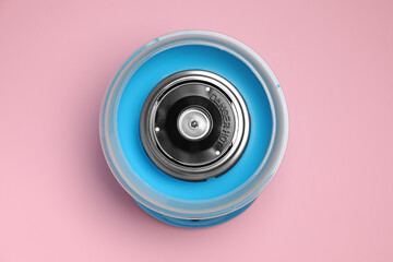 Portable candy cotton machine on pink background, top view
