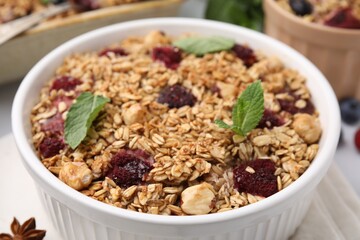 Tasty baked oatmeal with berries and nuts on table, closeup