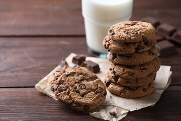 Delicious chocolate chip cookies on wooden table, space for text