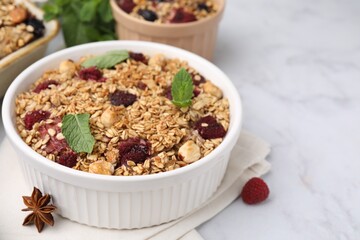 Tasty baked oatmeal with berries, nuts and anise star on white marble table, closeup. Space for text