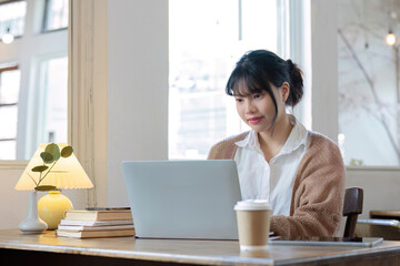 Asian female student studying online, studying on a video call, zoom call, passionate Asian female teacher learning English online with a laptop computer