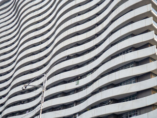 Unusual facade of a high-rise building. Architecture of Batumi. The wavy facade of the house. Balconies. Housing for many people