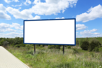 Empty signboard near road outdoors. Mock-up for design