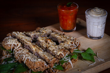 Breaded steak with cheese topping, arugula stuffing and tasty sauce