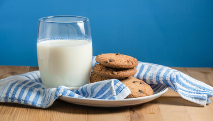 A glass of milk with chocolate chip cookies against a blue background