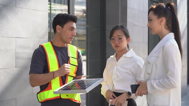Electrical Engineer Technician explaining or offer solar cells renewable energy installation in residence or building office in urban city outdoor. solar panel saving environment