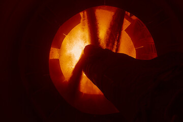Pouring lime into working area of rotating burning kiln
