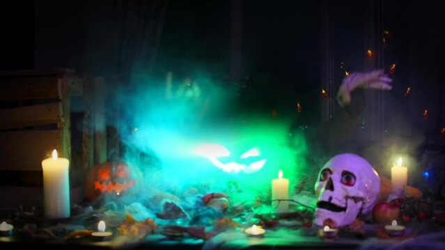 Creepy glowing Jack-o'-lantern flashing different lights and dancing skeletal hands in thick smoke among colorful garlands of flickering candles and skulls scary Halloween have a fun party invitation.